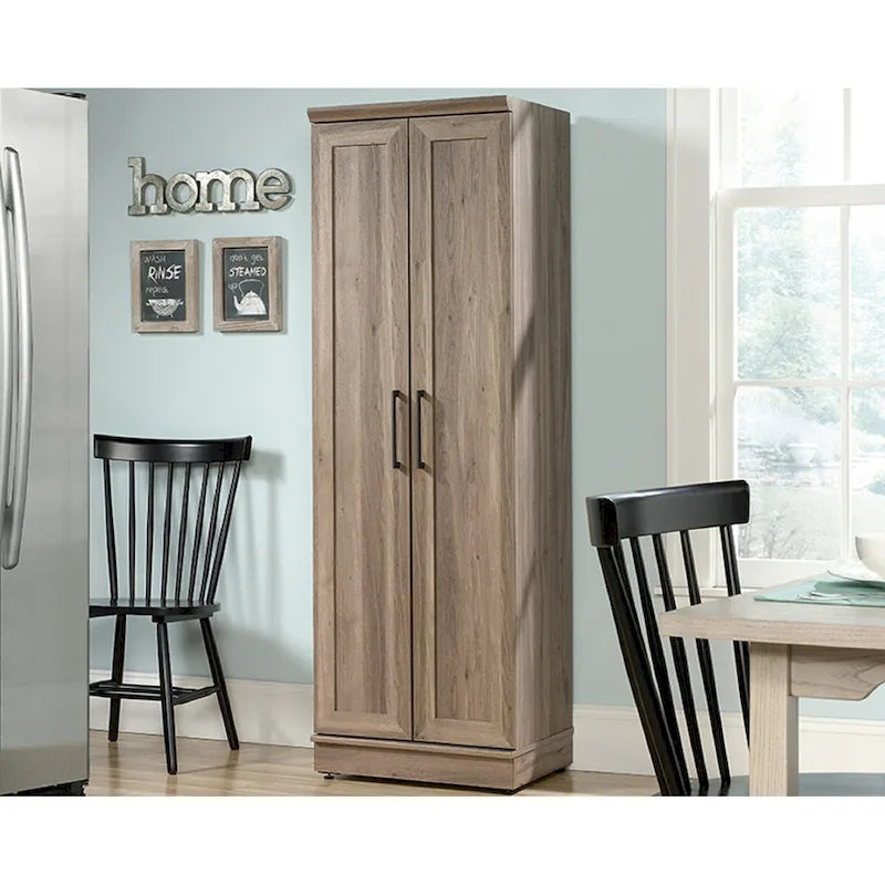 Armoire de rangement au fini chêne décapé, dotée de portes à panneaux et d'étagères réglables.