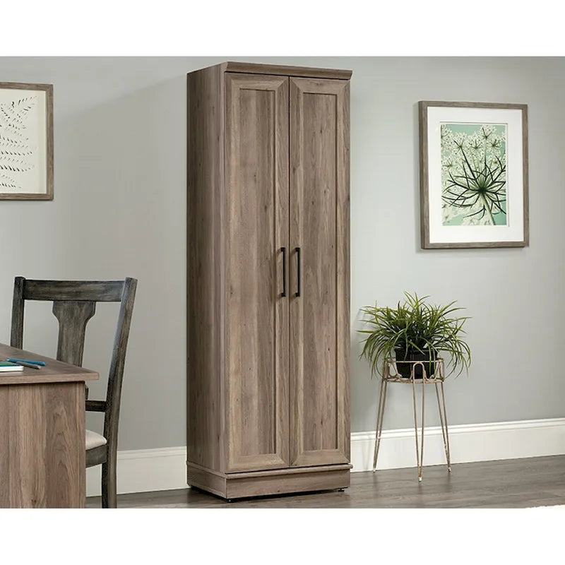 Armoire de rangement au fini chêne décapé, dotée de portes à panneaux et d'étagères réglables.
